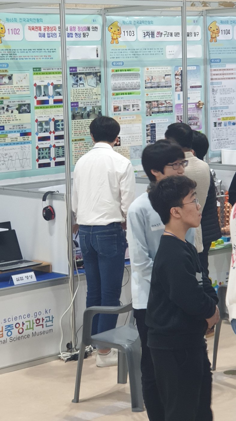 국립중앙과학관 제65회 전국과학전람회 전시장: 1102 차트가 붙은 부스 앞에 학생들이 서 있다